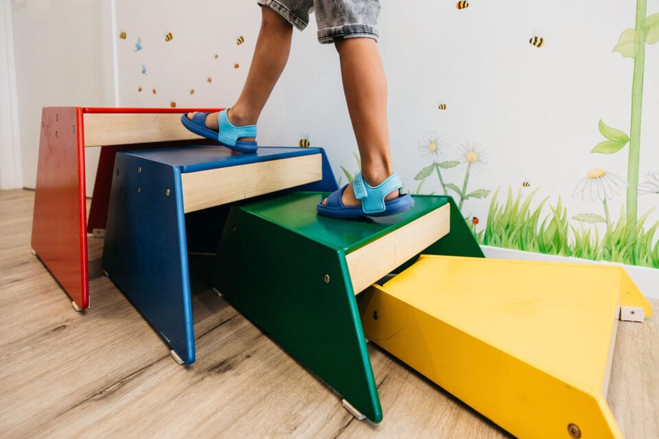 A child walking up blocks in occupational therapy