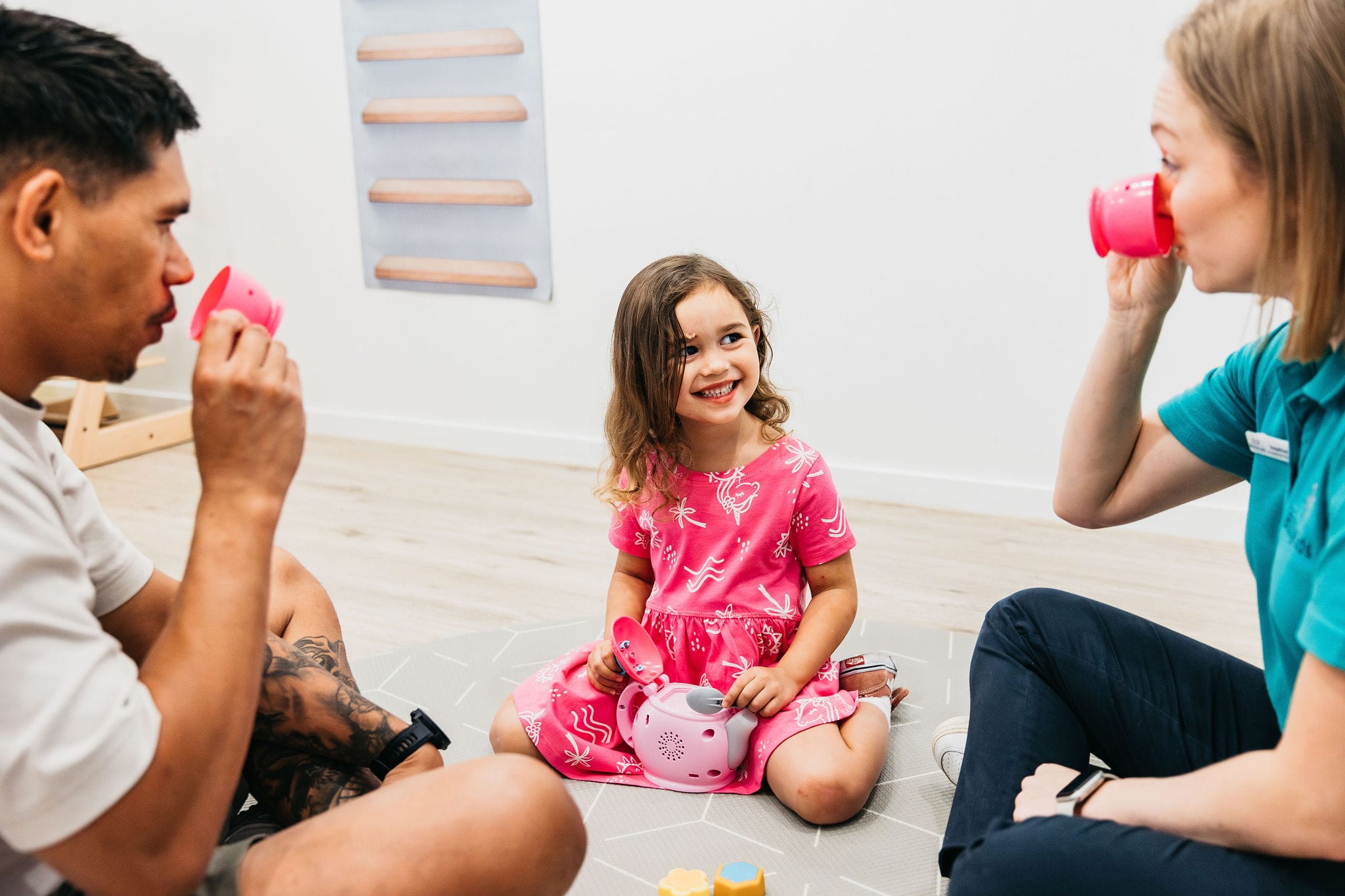 A child with her dad and occpuational therapist