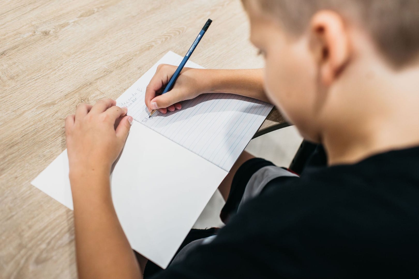 A child writing in a notebook in speech therapy