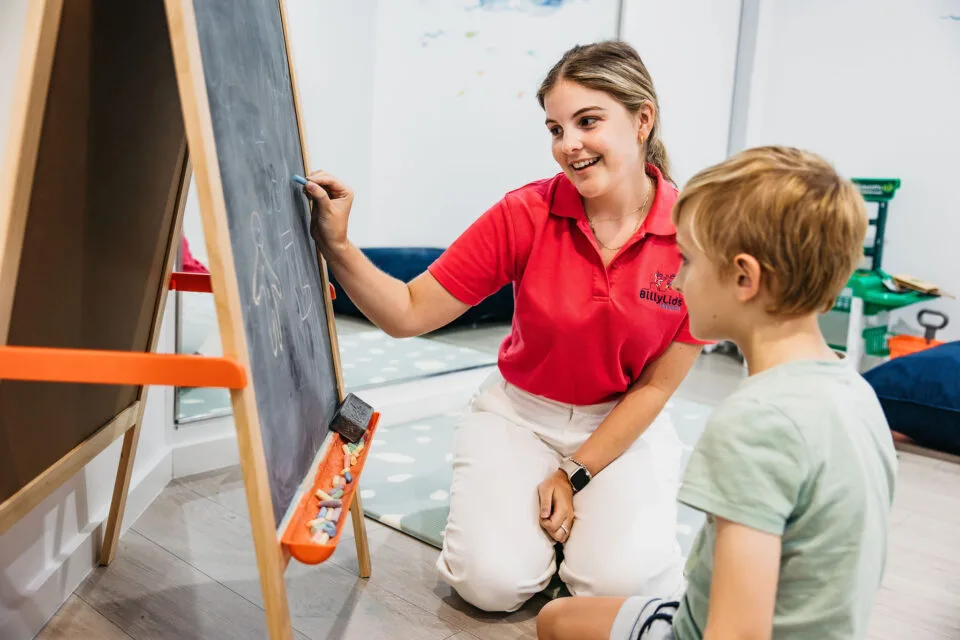 A speech therapist and child with a whiteboard