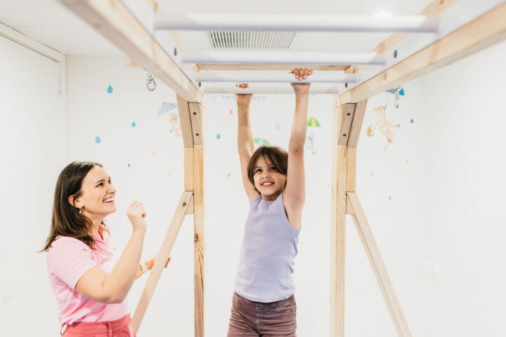 Child swinging on the monkey bars at BillyLids Occupational Therapy Clinic in Brisbane