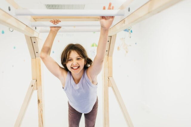 A child on the monkey bars in an occupational therapy session