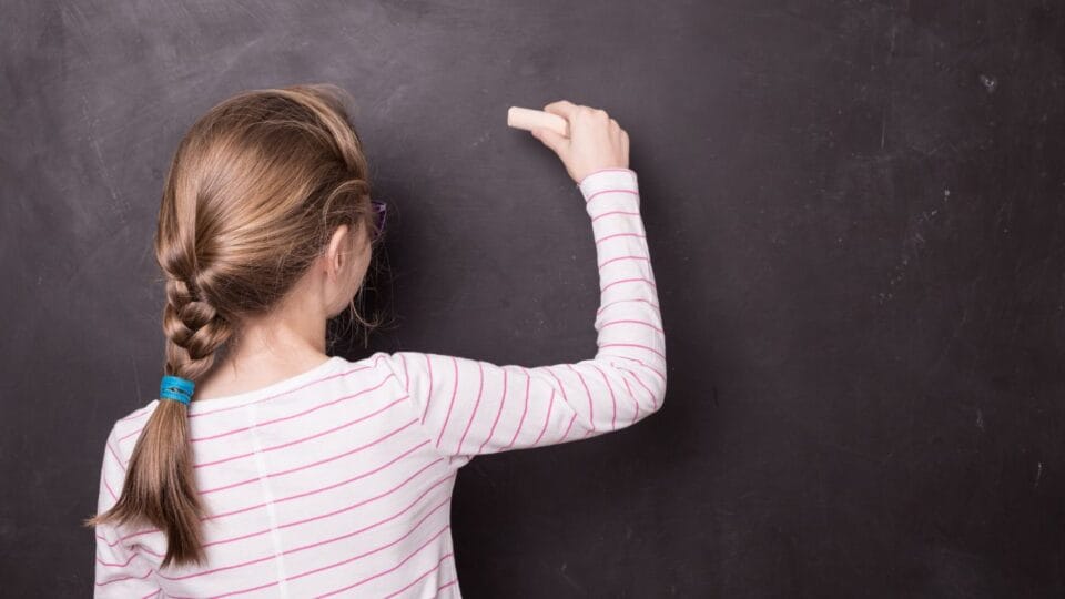 Child writing on a chalk board